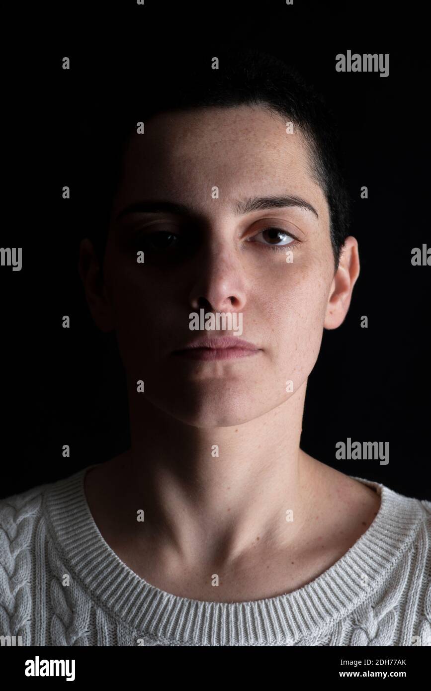 Shadowy portrait of beautiful woman looking at camera Stock Photo