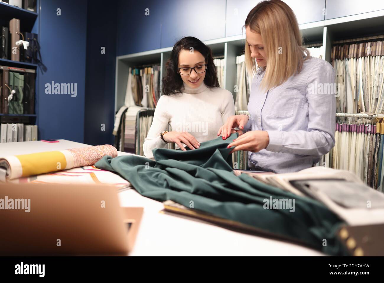 Consultant with customer is choosing fabrics in store. Stock Photo