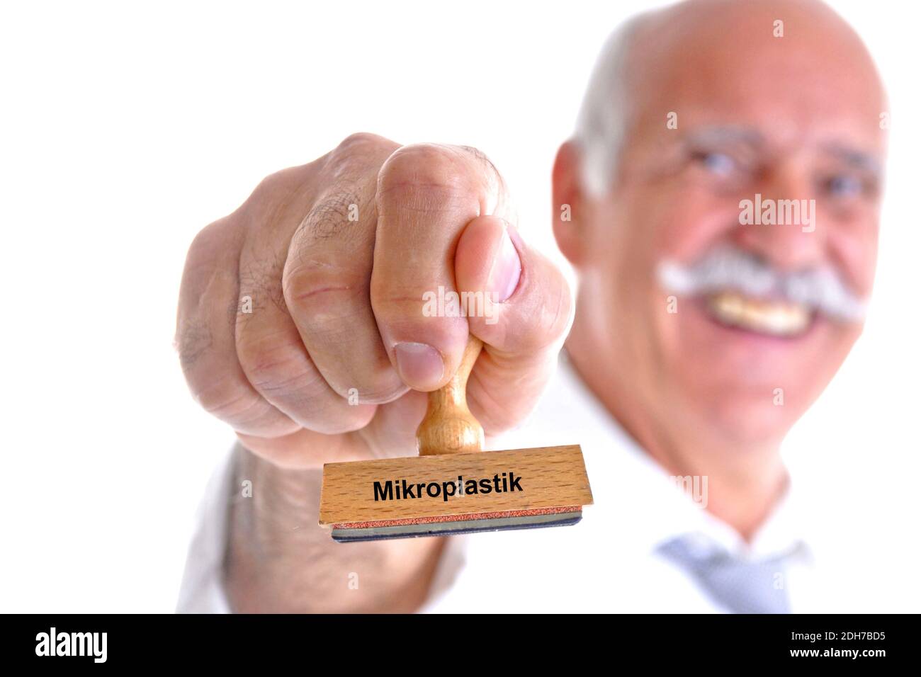 65, 70, Jahre, Mann hält Stempel in der Hand, Aufschrift: Mikroplastik, Stock Photo