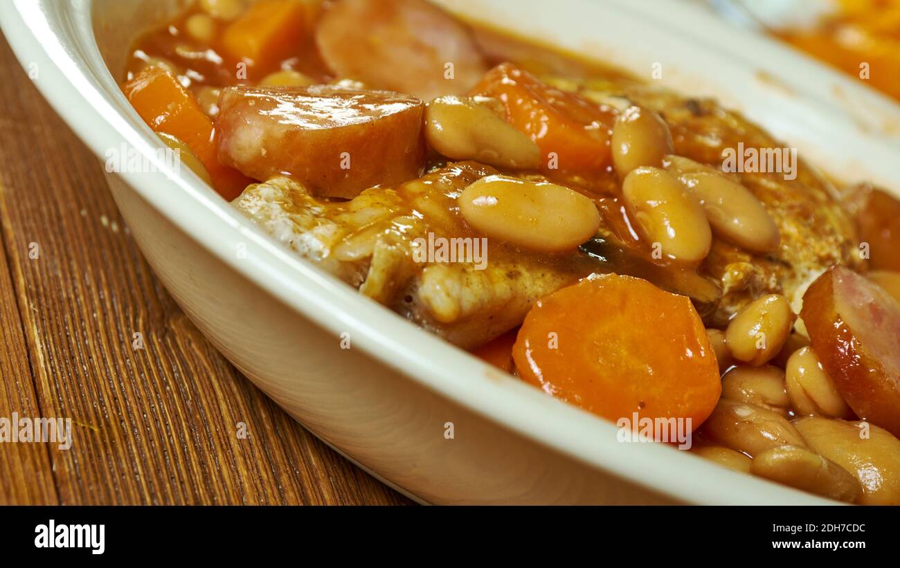 British pork cassoulet, filling pork dish with beans,pork sausages,  tomatoes and carrots Stock Photo