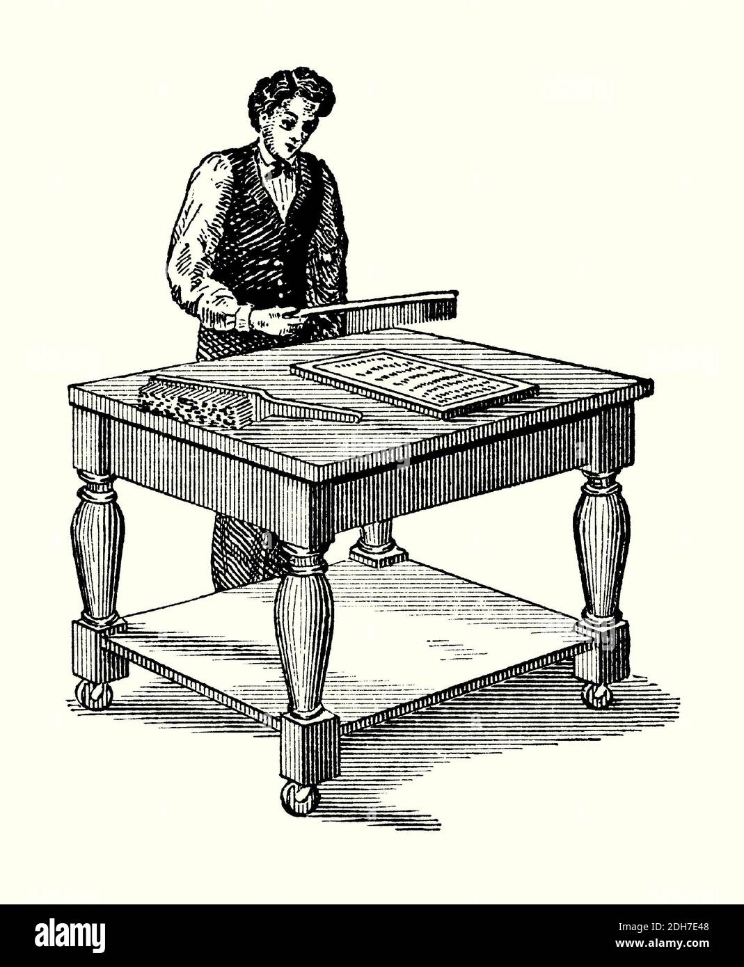 An old engraving of a worker at a beating table making stereotype moulds (flongs) in the 1800s. It is from a Victorian book of the 1880s. Here a worker pats down (beats) the damp layers of paper within the iron tray containing a page of type. In printing, a stereotype, (stereoplate or stereo) is a solid plate of type metal (forme), cast in hot metal from a papier-mâché or plaster mould (flong) with the imprint of the letters of type in its surface. The forme was used on the printing press. Papier-mâché (‘chewed’, ‘pulped’ or ‘mashed’ paper) consists of paper pieces bound with an adhesive. Stock Photo