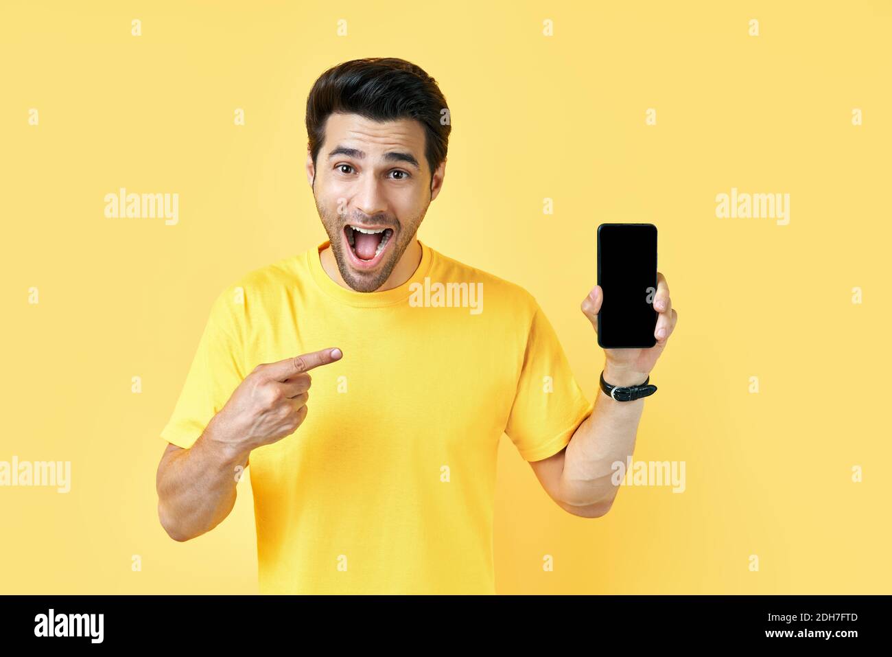 Excited screaming man pointing his finger showing mobile phone and looking to camera Stock Photo