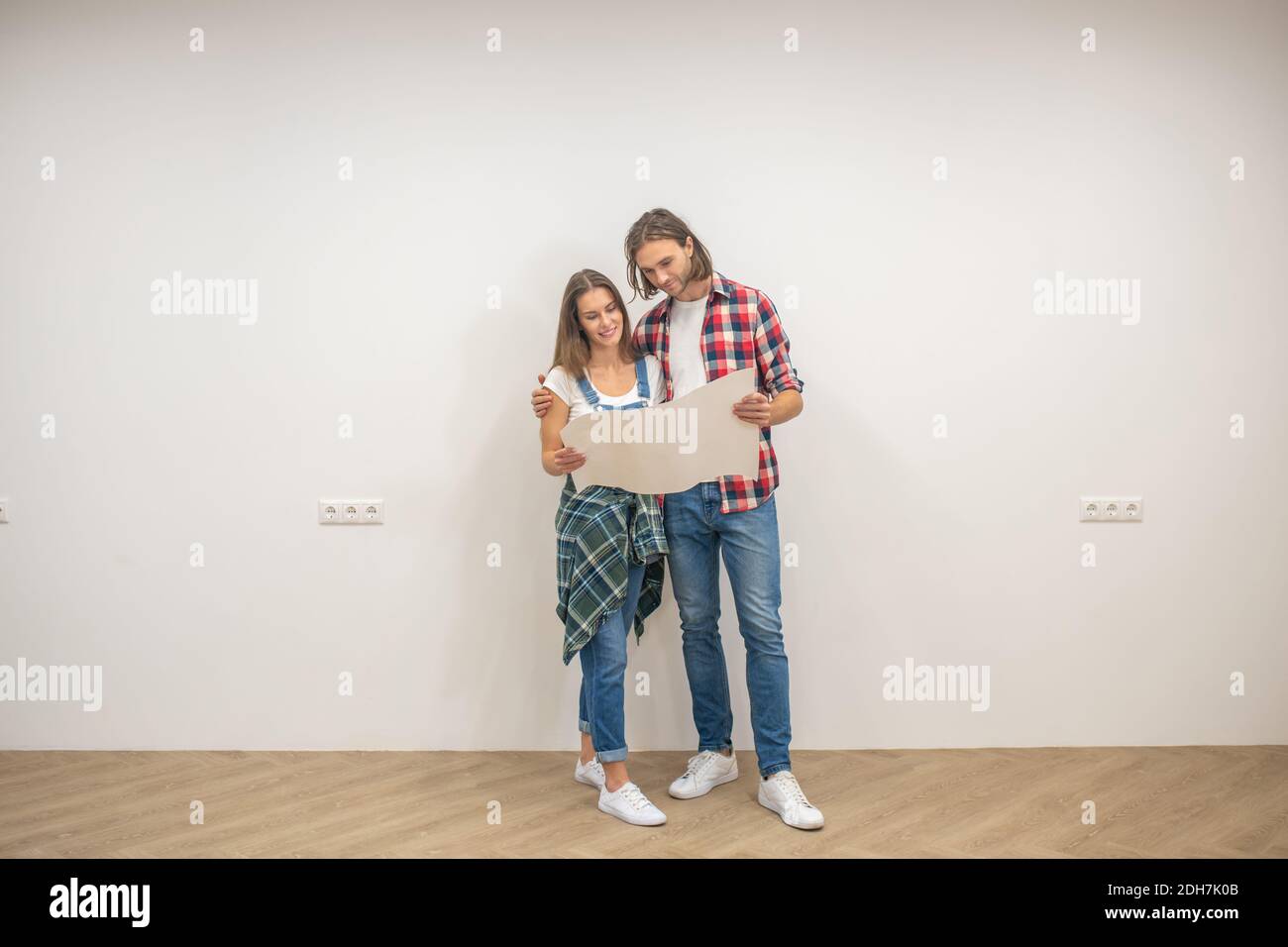 Young man and woman holding a design project and looking at it Stock Photo