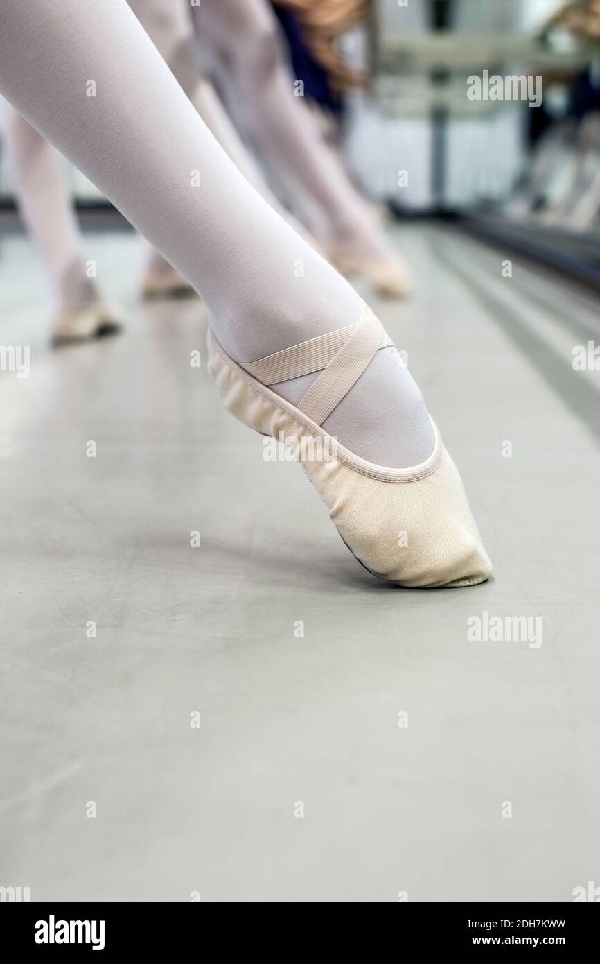 Young ballerinas dancing at dance studio, close up of ballet shoes. Stock Photo