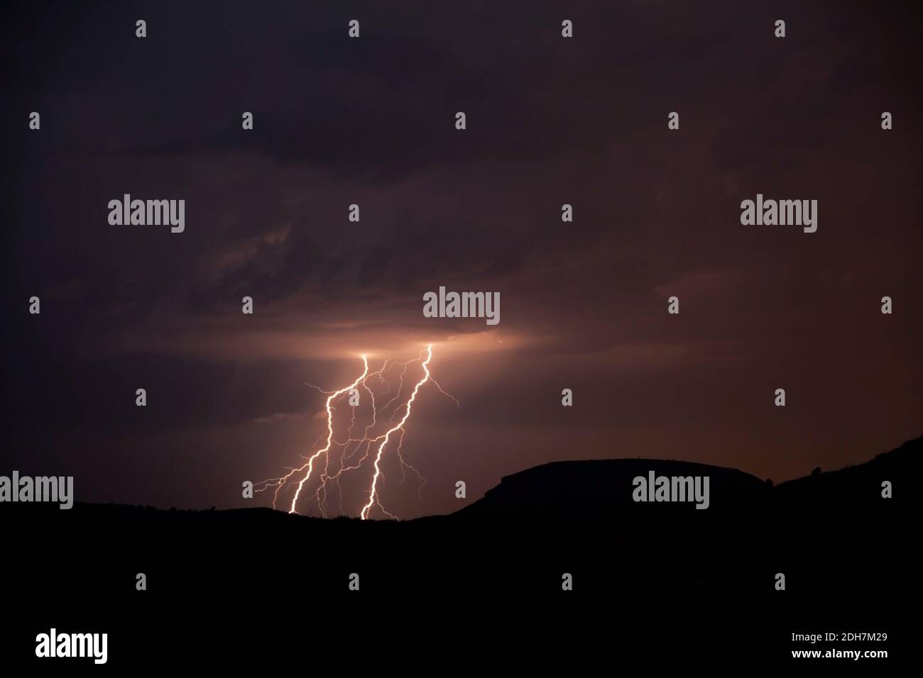 A silhouette shot of mountains with lightning bolts background Stock Photo
