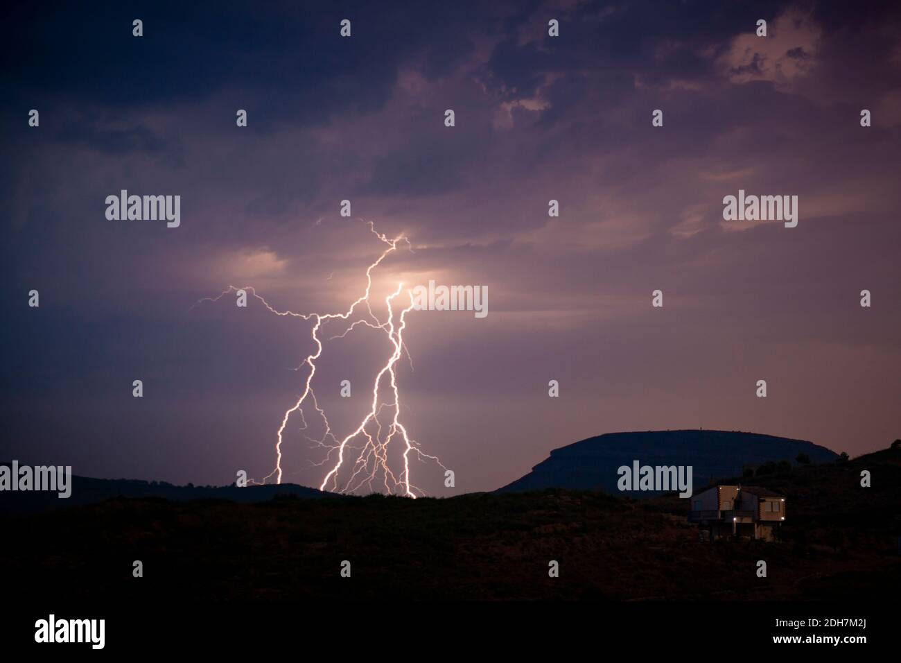 A silhouette shot of mountains with lightning bolts background Stock Photo
