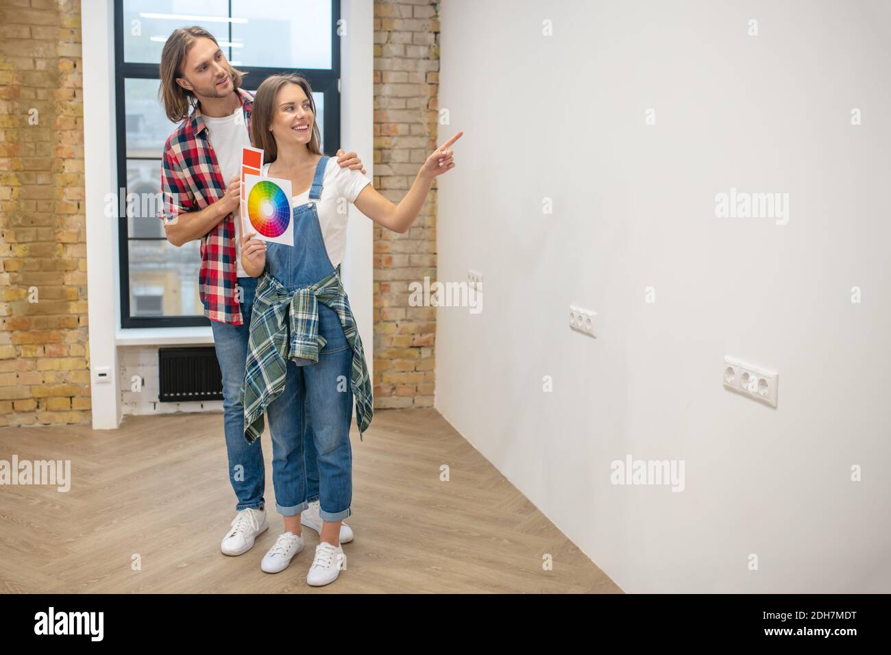 Couple discussing the color for walls and looking involved Stock Photo