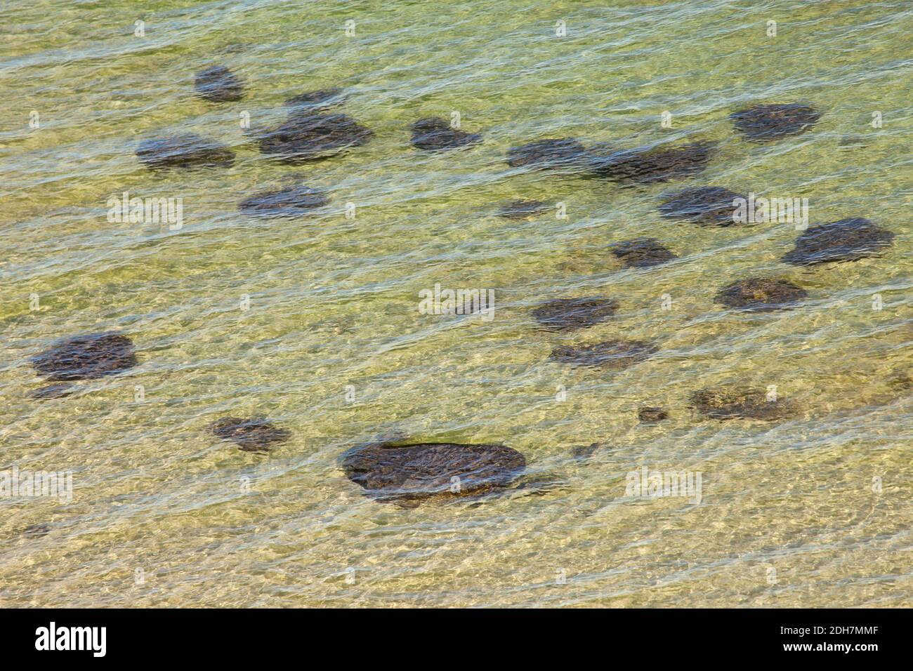Dark rocks under surface of water, conceptual Stock Photo
