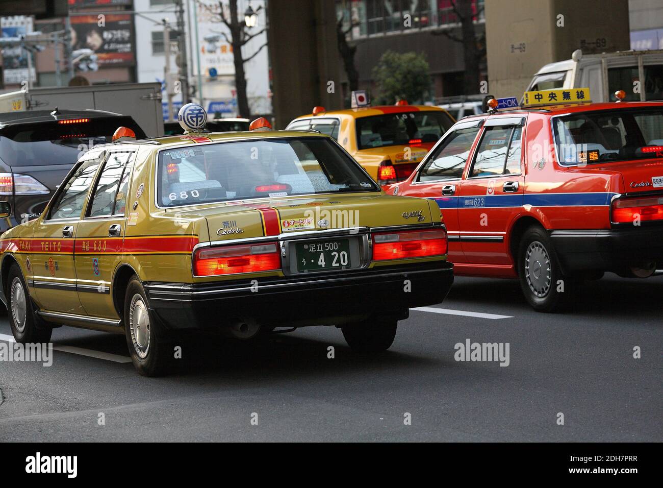 Typical local Japanese Taxis standing in traffic in Tokyo, Japan . Stock Photo