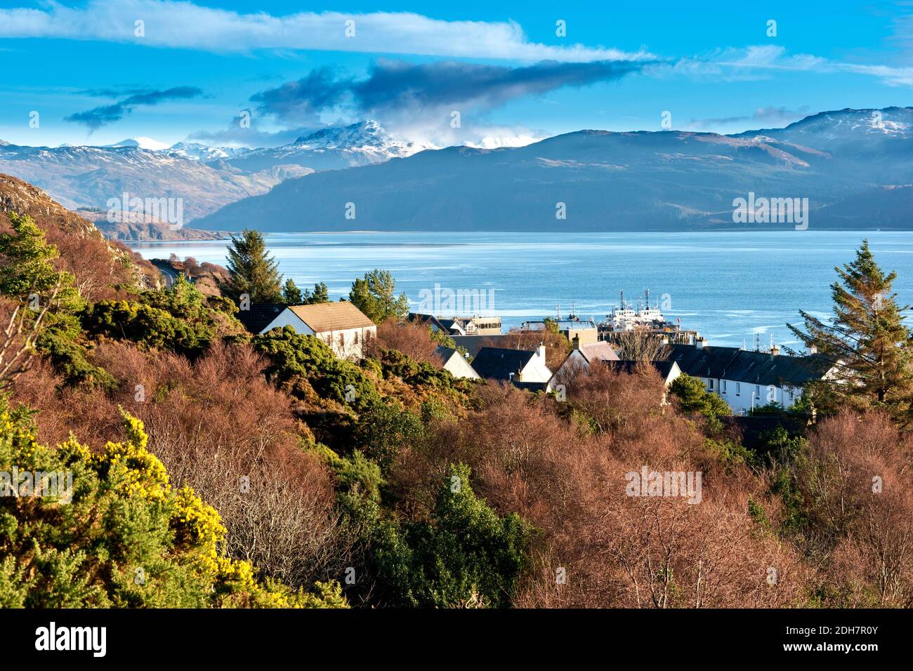 KYLE OF LOCHALSH  ROSS-SHIRE SCOTLAND RUGGED COASTLINE  LOOKING DOWN TO HARBOUR AREA LOCH ALSH AND SNOW COVERED MOUNTAINS Stock Photo