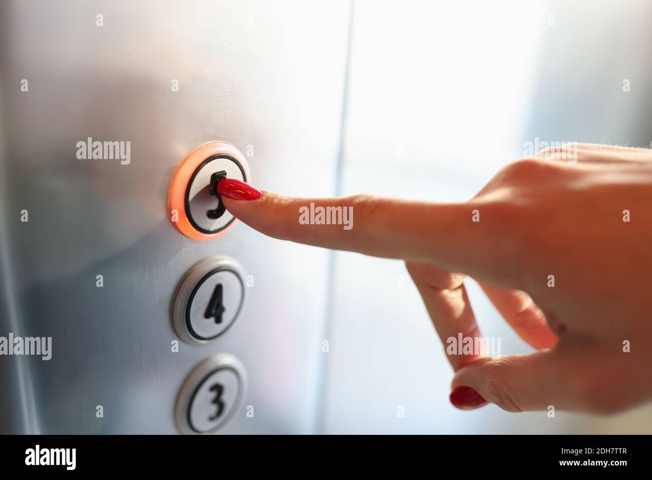 Womans hand pressing button of elevator to fifth floor closeup Stock Photo Alamy