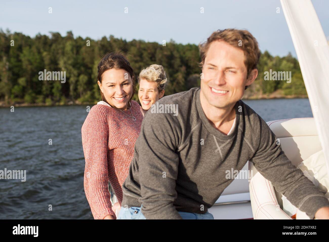 Happy friends travelling on yacht at river Stock Photo