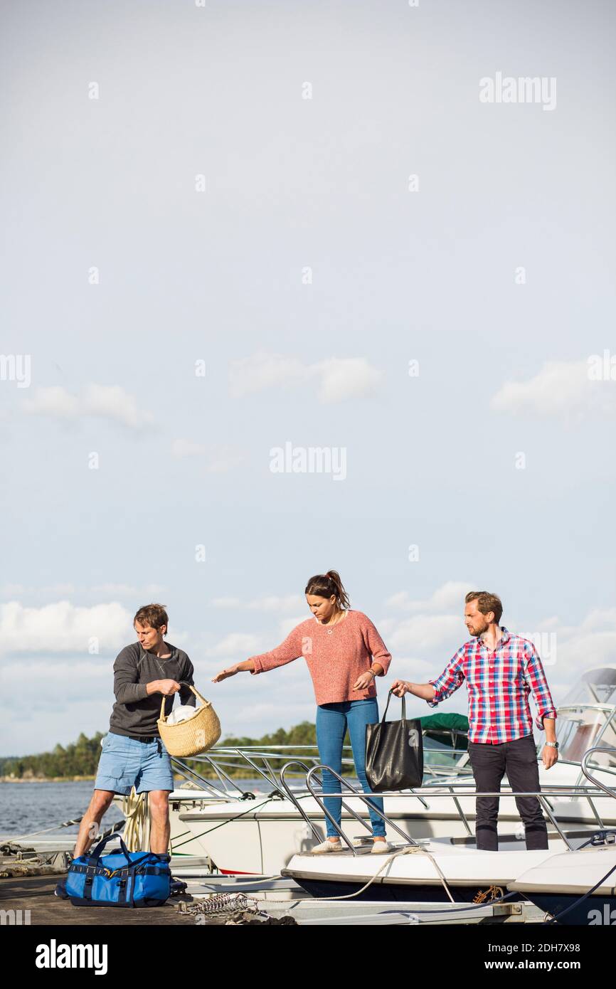 Friends boarding yacht against sky Stock Photo
