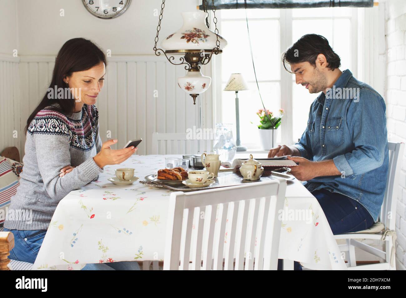 Side view of mid adult couple spending leisure time at breakfast table Stock Photo