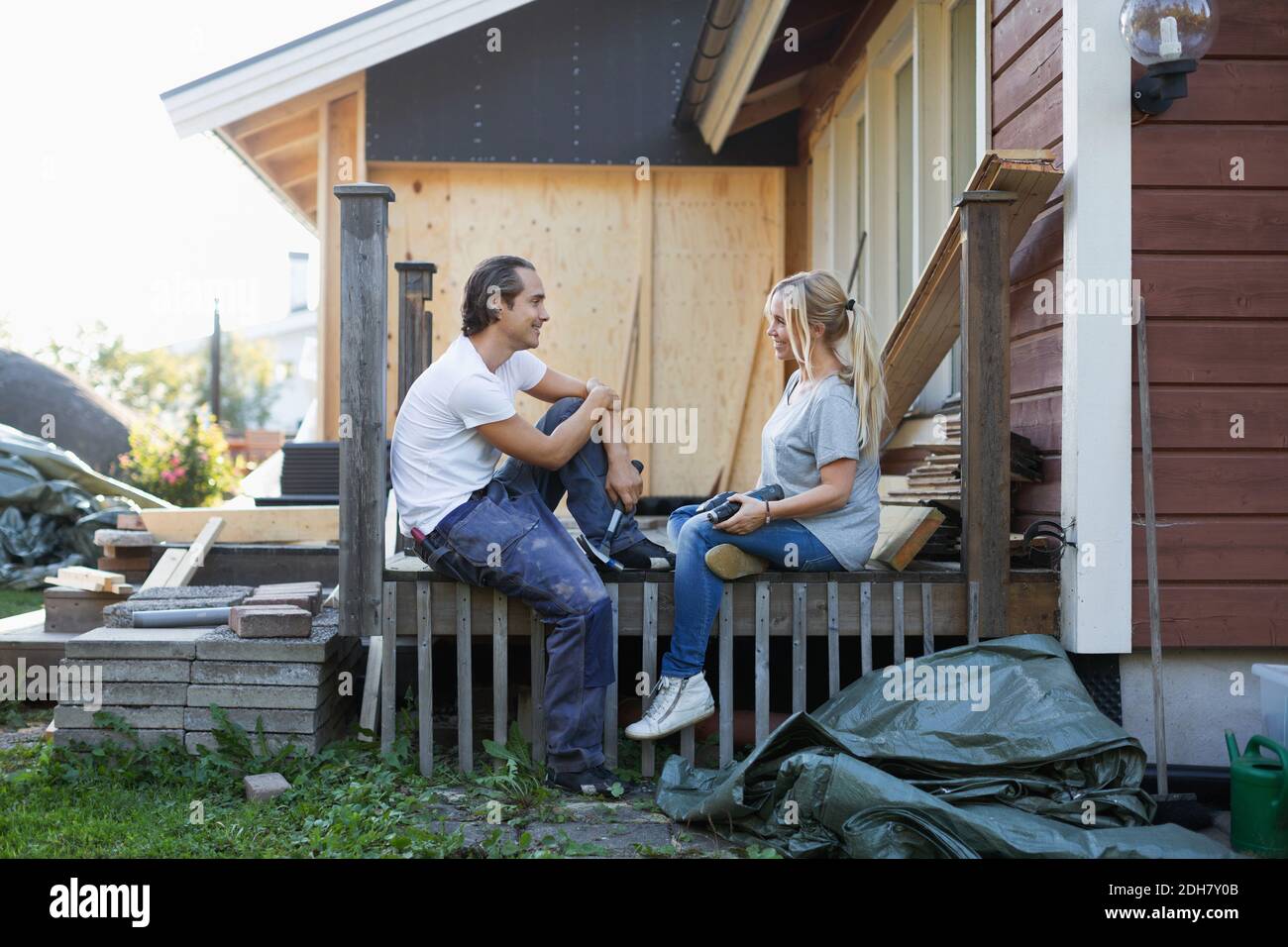 Happy couple looking at each other while renovating house Stock Photo
