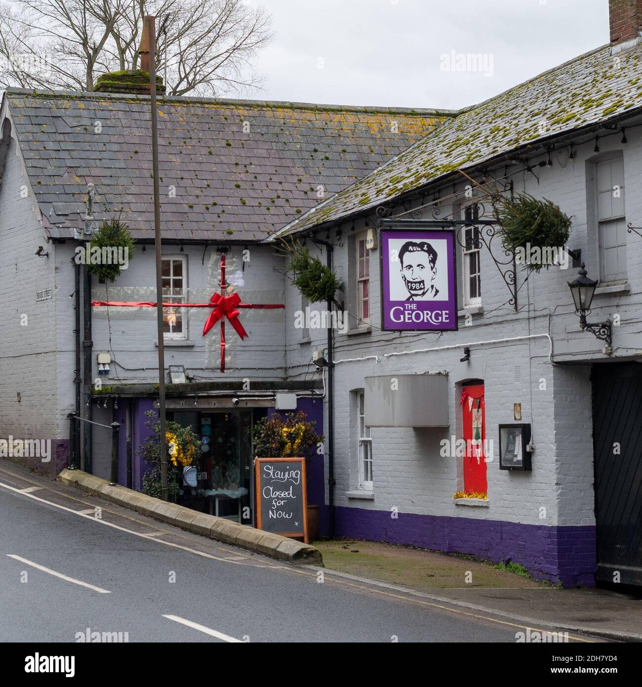 Fordingbridge, New Forest, Hampshire, UK, 10th December 2020. The George riverside pub remains closed after Lockdown 2 with the area now in Tier 2 of coronavirus restrictions. The New Forest district was in Tier 1 before the second lockdown. A new pub sign hangs outside the entrance. Credit: Paul Biggins/Alamy Live News Stock Photo
