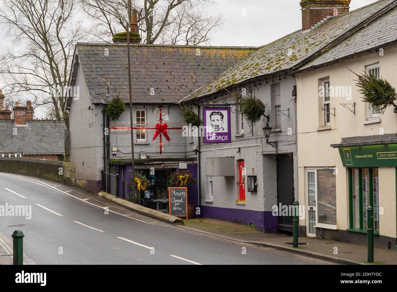 Fordingbridge, New Forest, Hampshire, UK, 10th December 2020. The George riverside pub remains closed after Lockdown 2 with the area now in Tier 2 of coronavirus restrictions. The New Forest district was in Tier 1 before the second lockdown. A new pub sign hangs outside the entrance. Credit: Paul Biggins/Alamy Live News Stock Photo