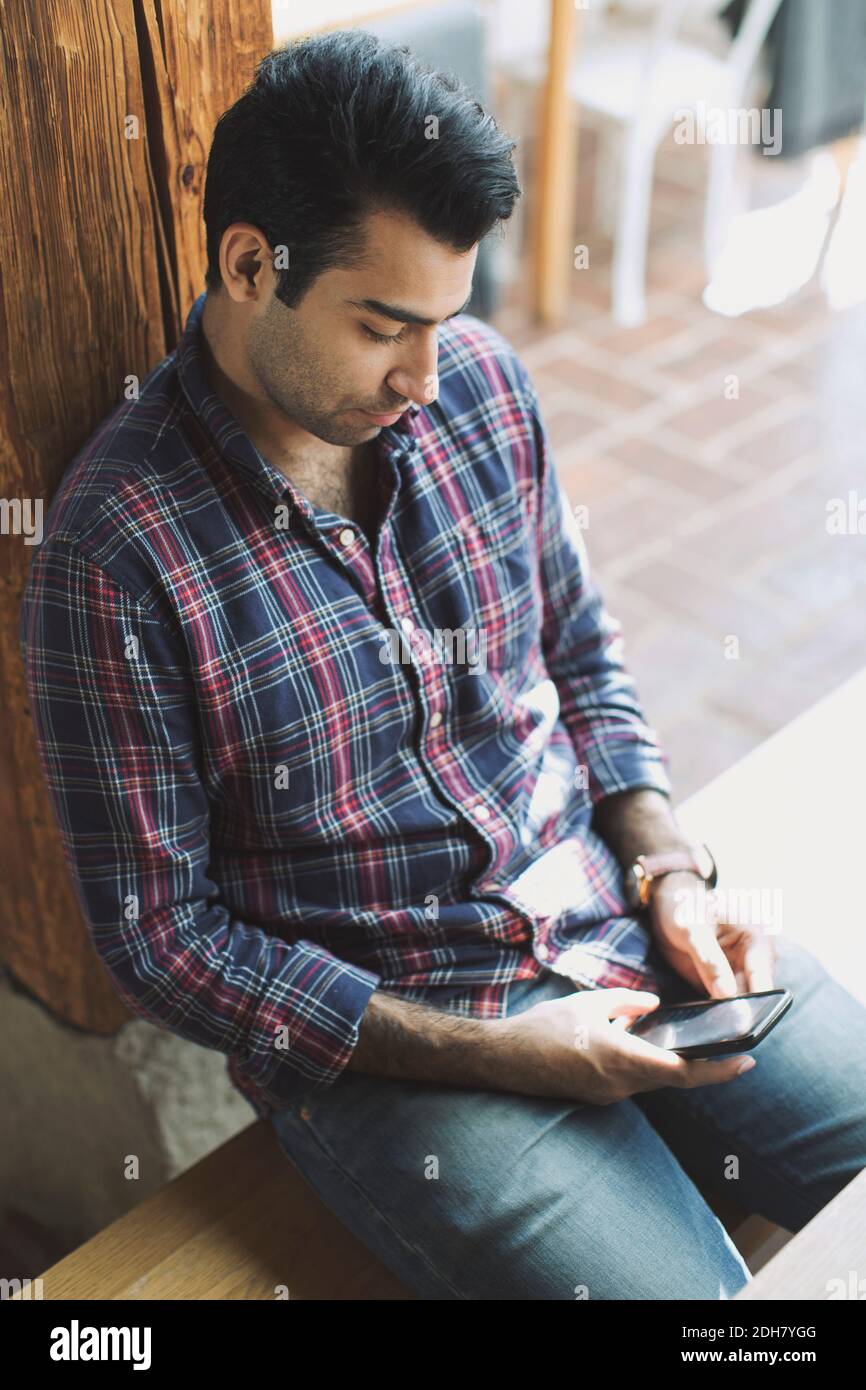 Man using smart phone in restaurant Stock Photo
