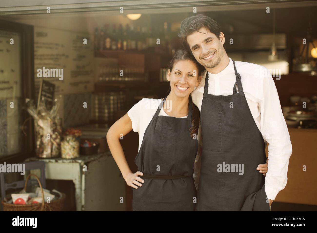 Portrait of happy business couple standing outside restaurant Stock Photo