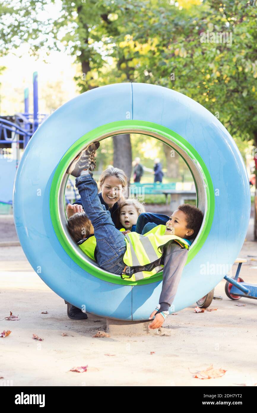 Teacher and children playing in tube Stock Photo