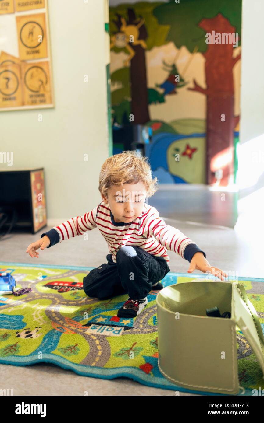 Boy removing toys from box in kindergarten Stock Photo