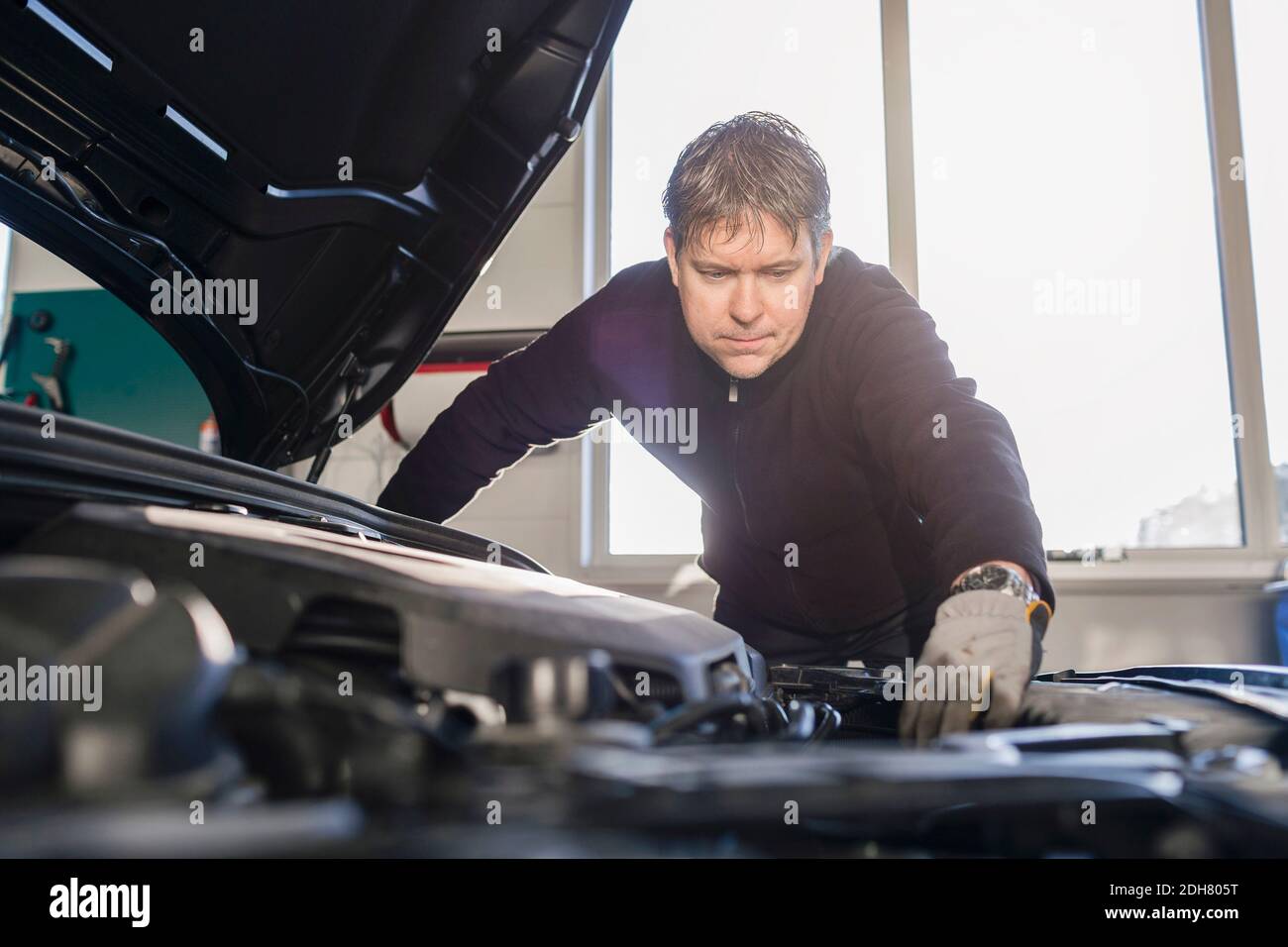 Mechanic repairing car engine in auto repair shop Stock Photo - Alamy