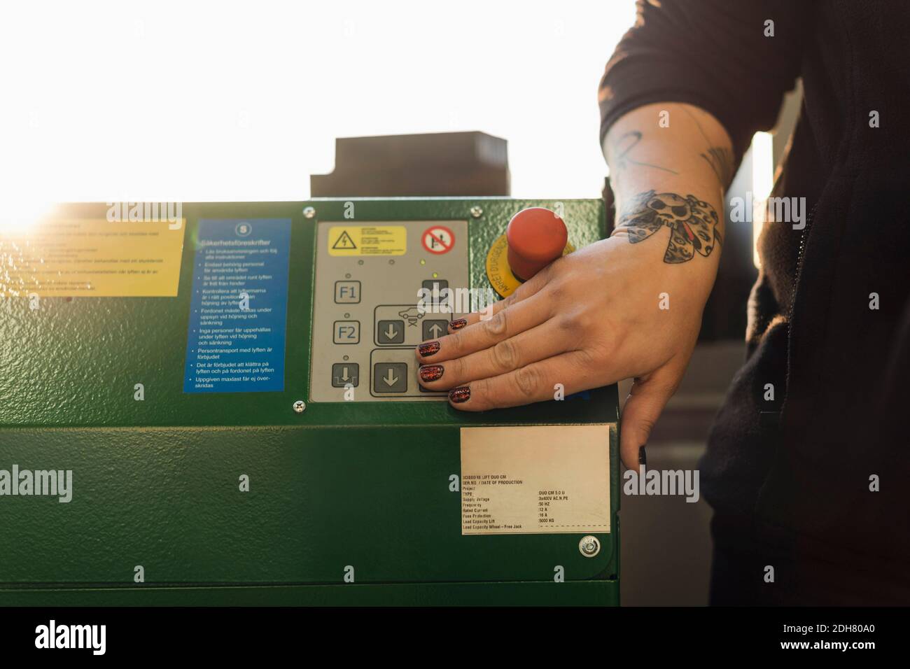 Cropped image of female mechanic using machine in auto repair shop Stock Photo