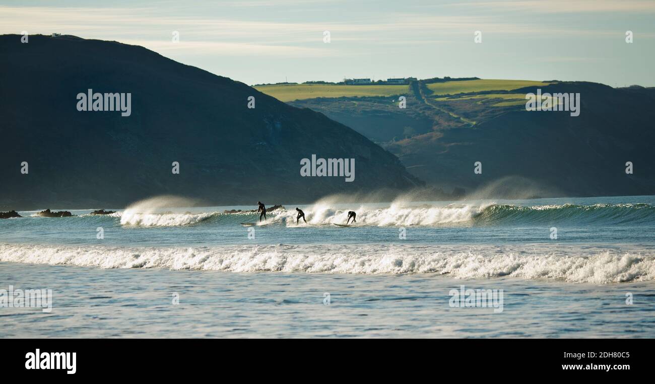 Surfers surfing the waves at Widemouth bay, Cornwall, UK Stock Photo