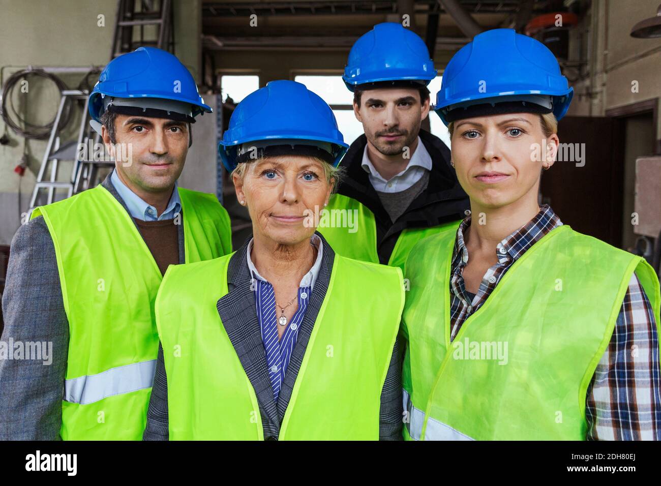 Team of manual workers in protective workwear at factory Stock Photo
