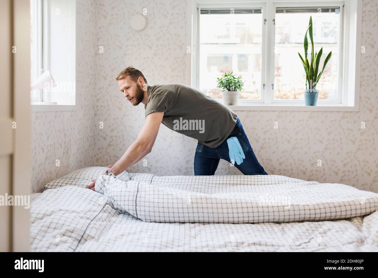 Man making bed Stock Photo