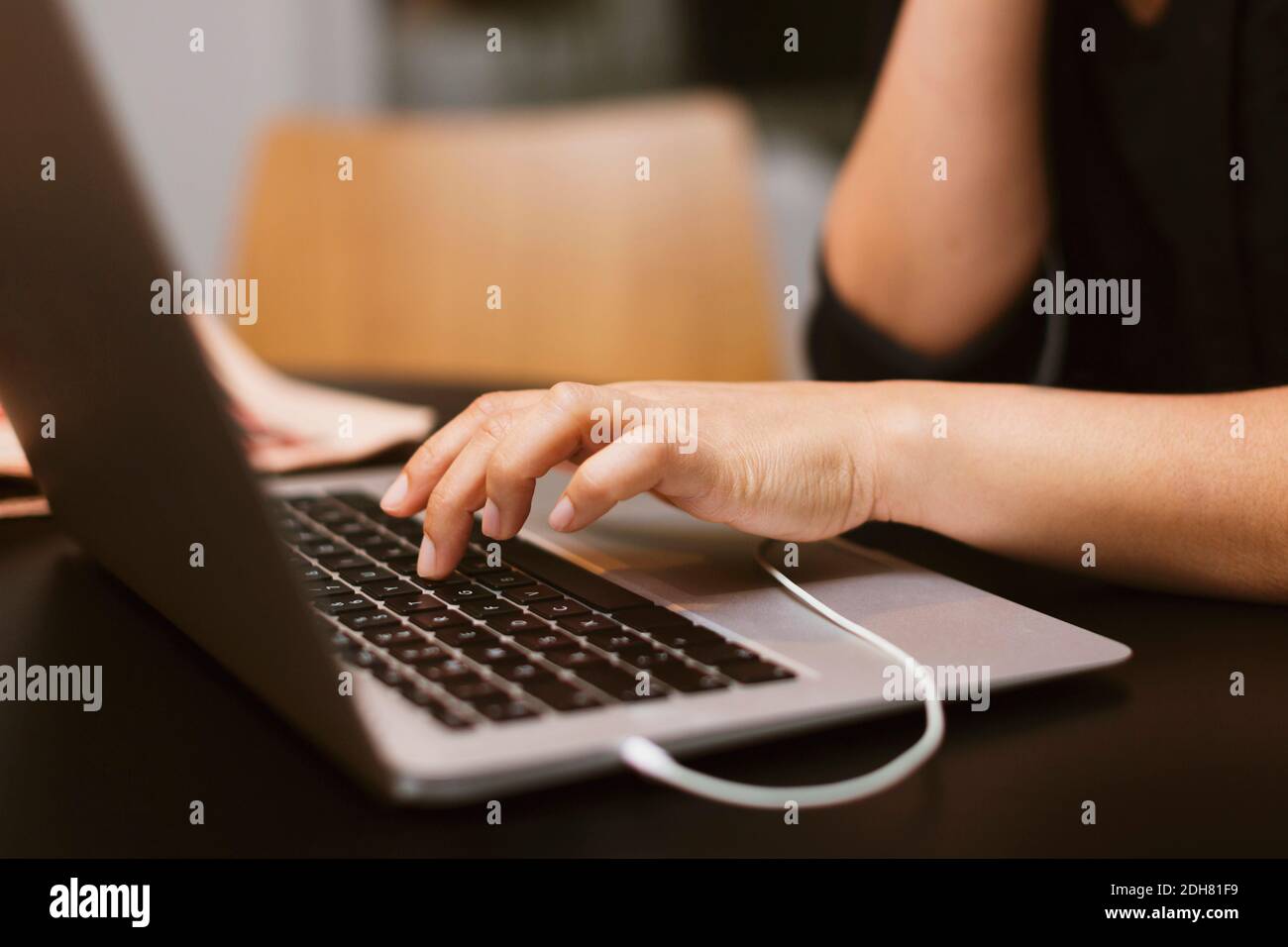 Midsection of businesswoman using laptop in office Stock Photo