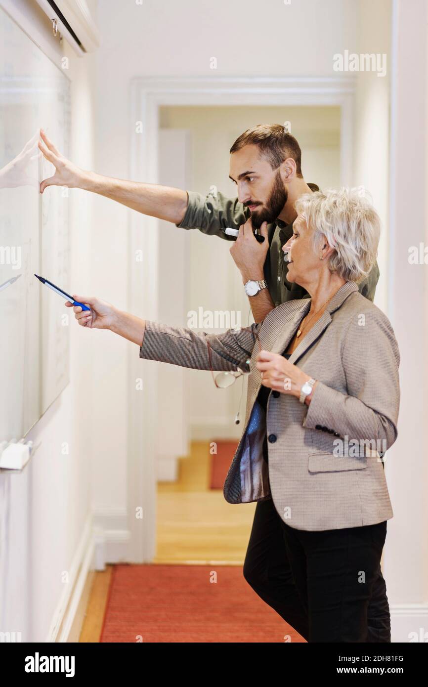 Senior woman explaining presentation to male colleague in office Stock Photo