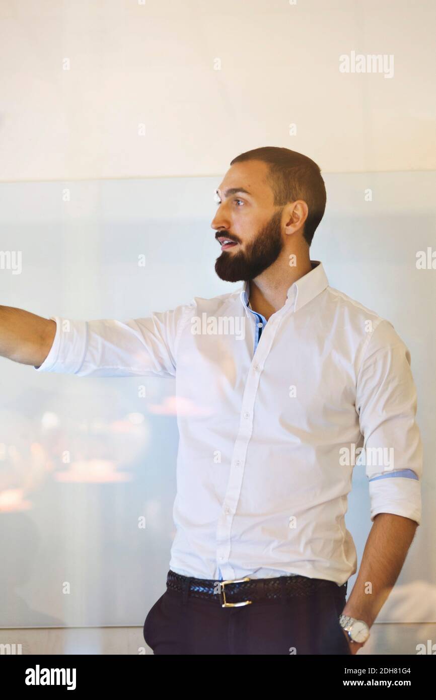 Confident businessman giving presentation in office Stock Photo - Alamy