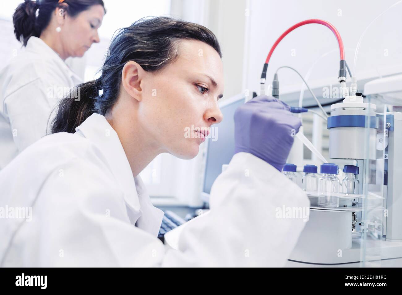 Female scientist using pipette in laboratory Stock Photo