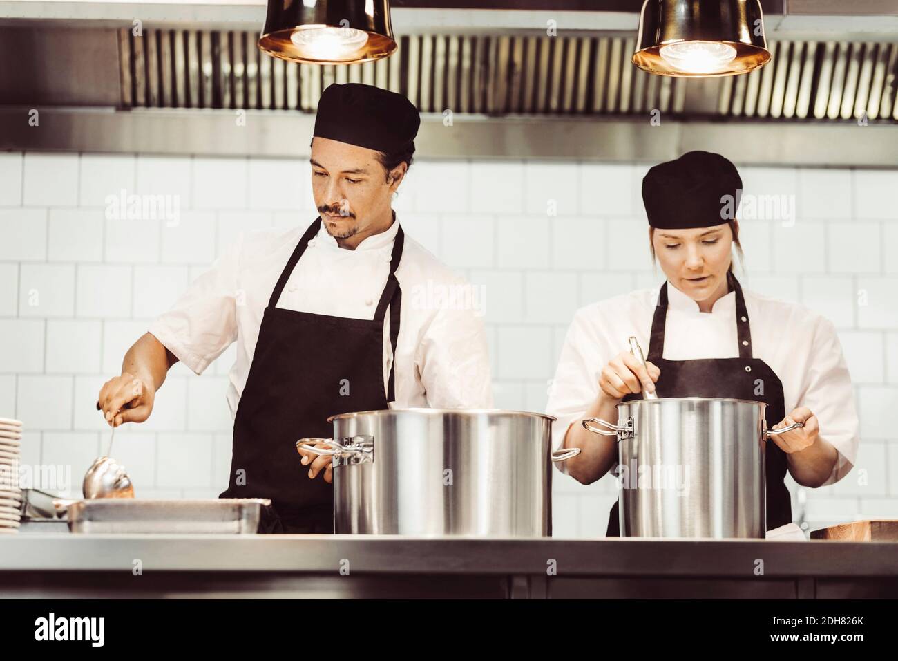 Chefs preparing food at kitchen counter Stock Photo
