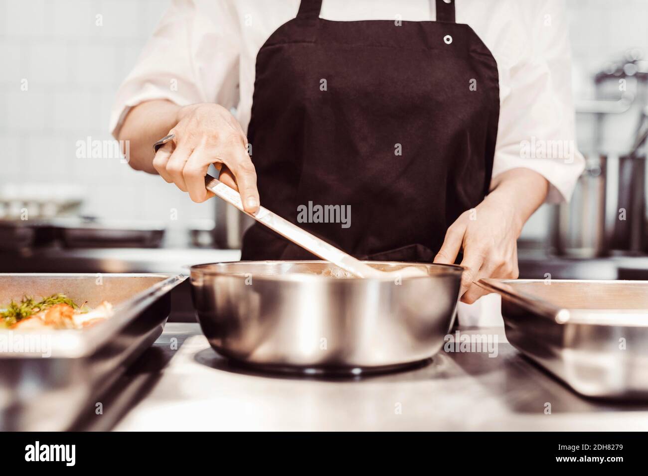 Händerna av kvinnlig kock som rör om i stekpanna Stock Photo - Alamy
