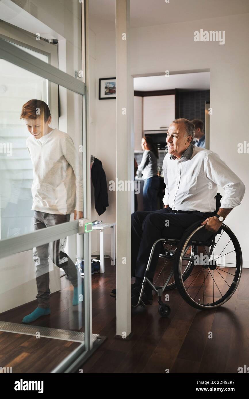 son and father entering wheelchair lift at home Stock Photo Alamy