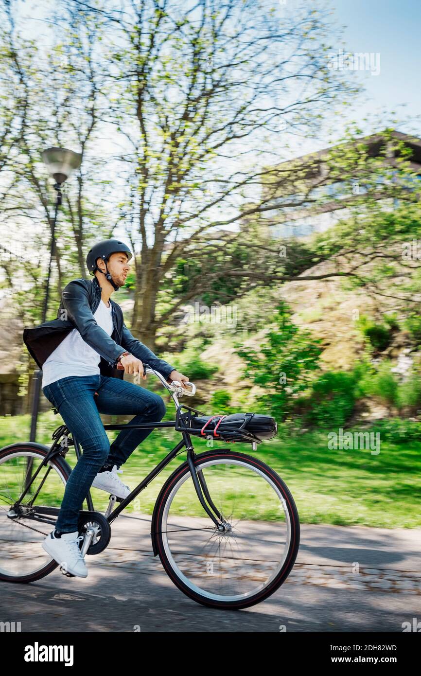 Businessman riding bicycle on street Stock Photo