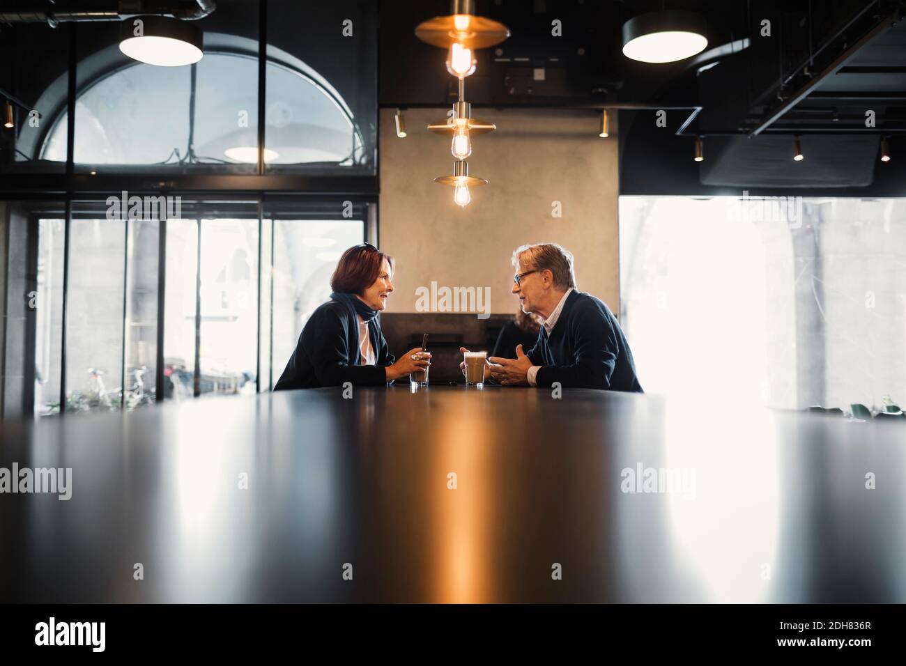 Senior couple talking while having coffee at cafeteria Stock Photo