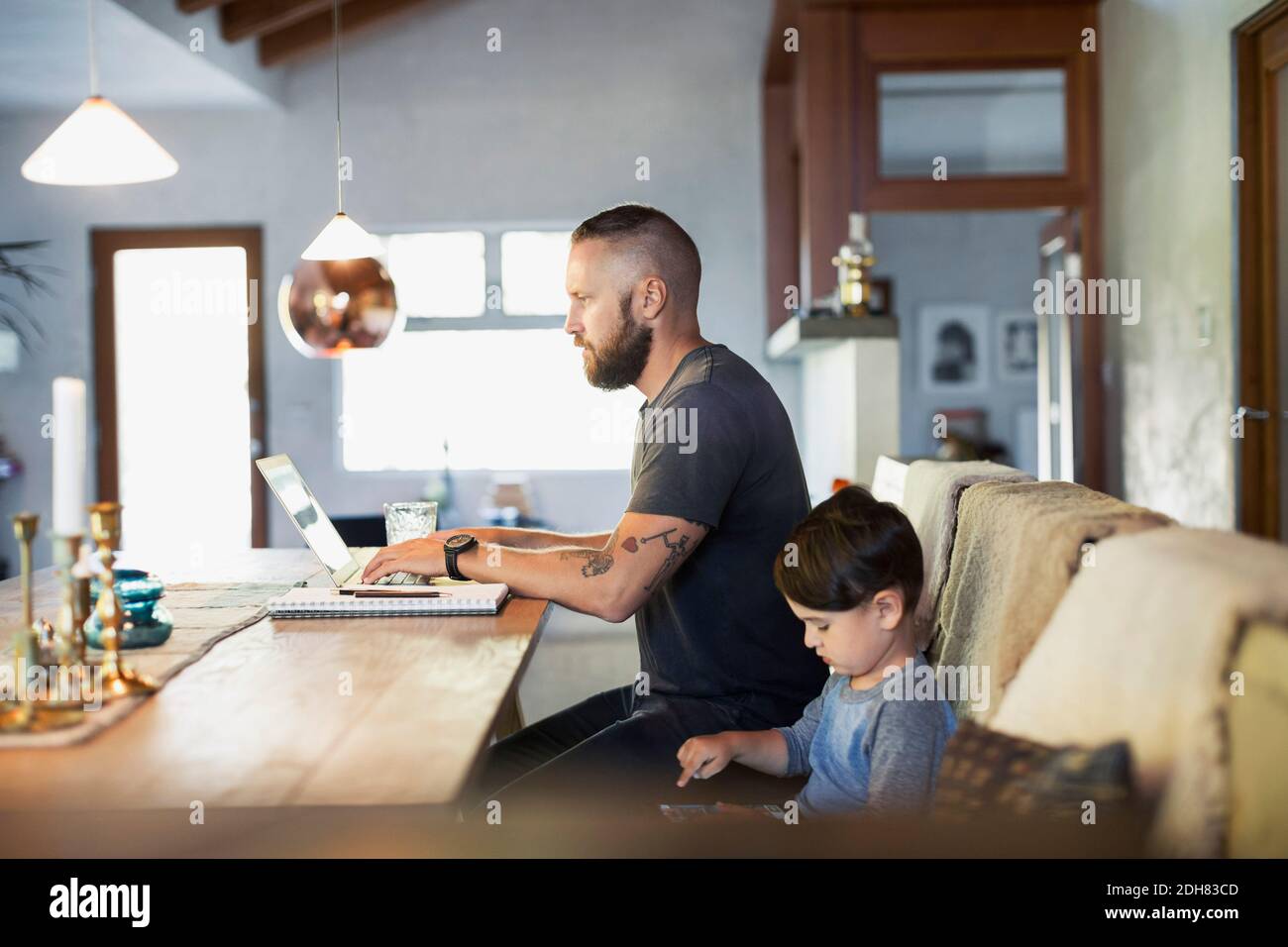 Side view of father and son using technologies at dining table Stock Photo