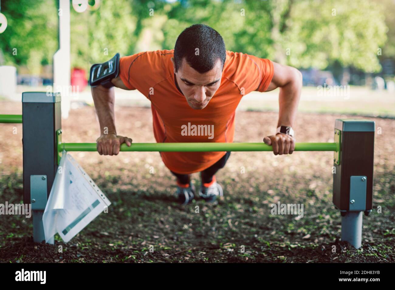 Man doing push-ups on railing at park Stock Photo - Alamy