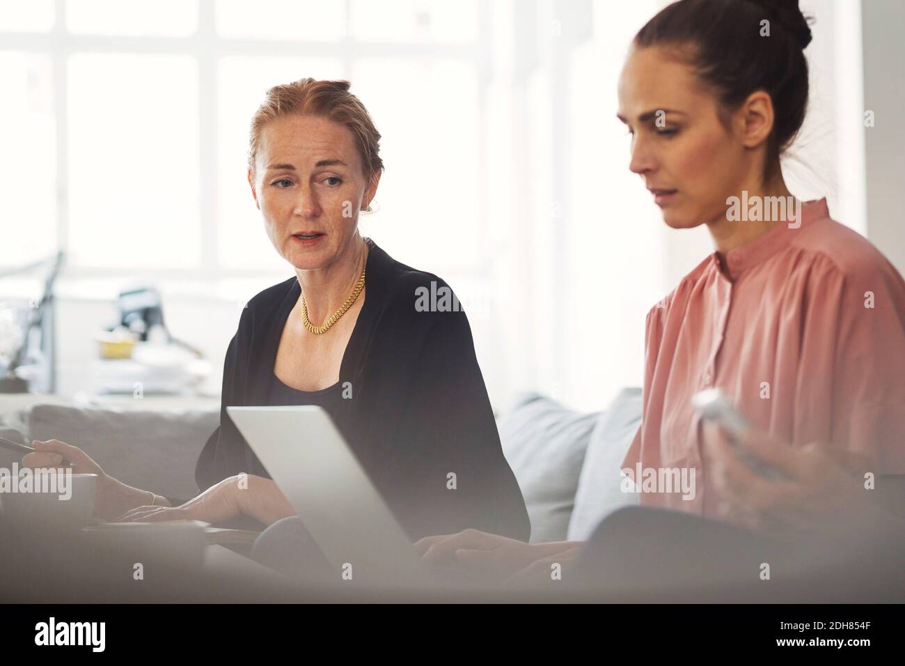 Businesswomen working together in office lobby Stock Photo - Alamy