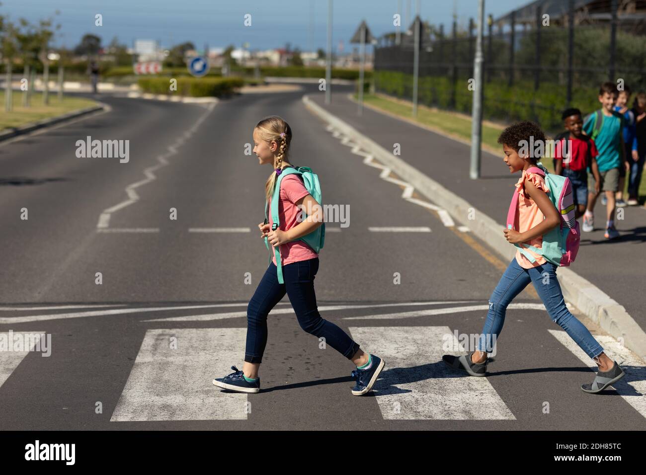 Two schoolgirls crossing the road on a pedestrian crossing Stock Photo ...
