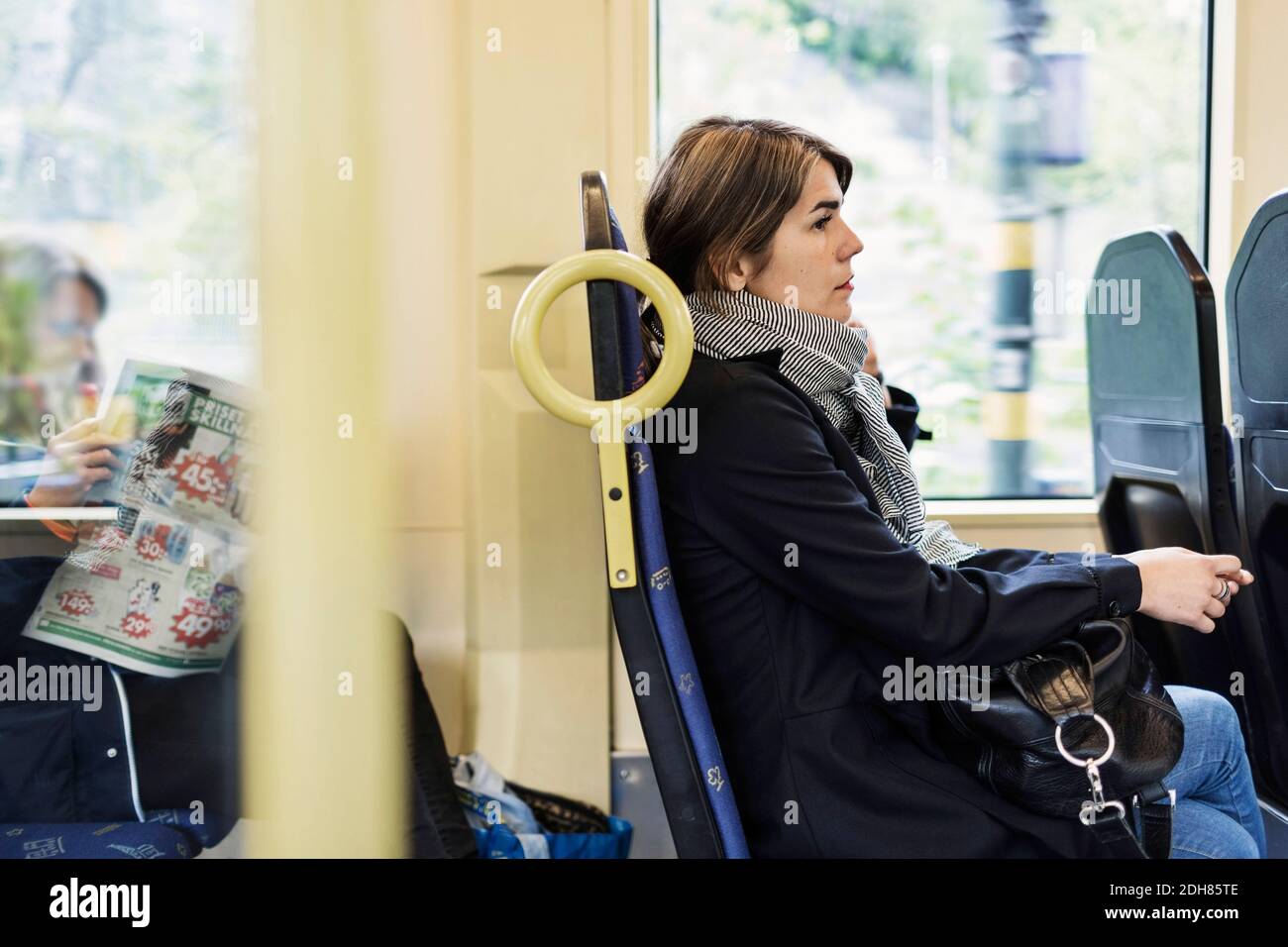 Side view of young woman sitting in tram Stock Photo