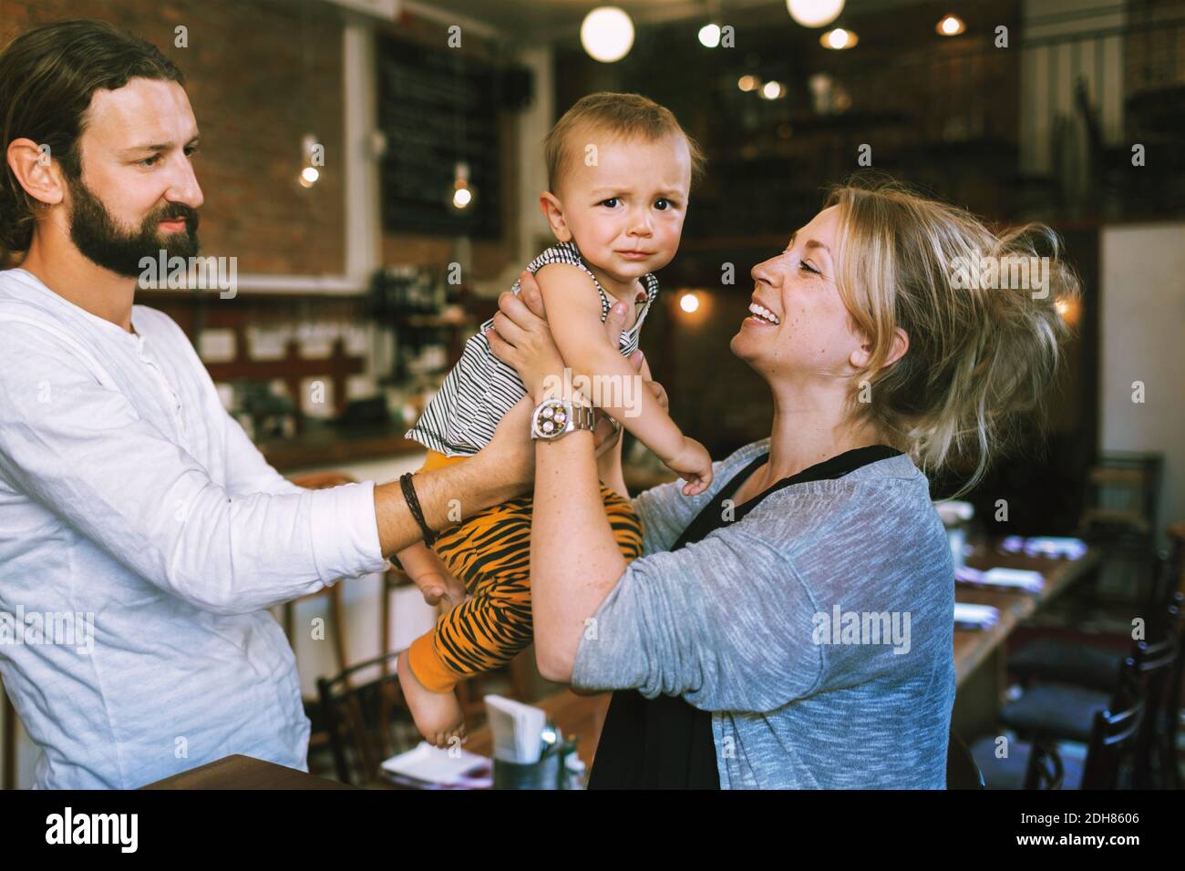 Happy mid adult parents with baby boy in restaurant Stock Photo