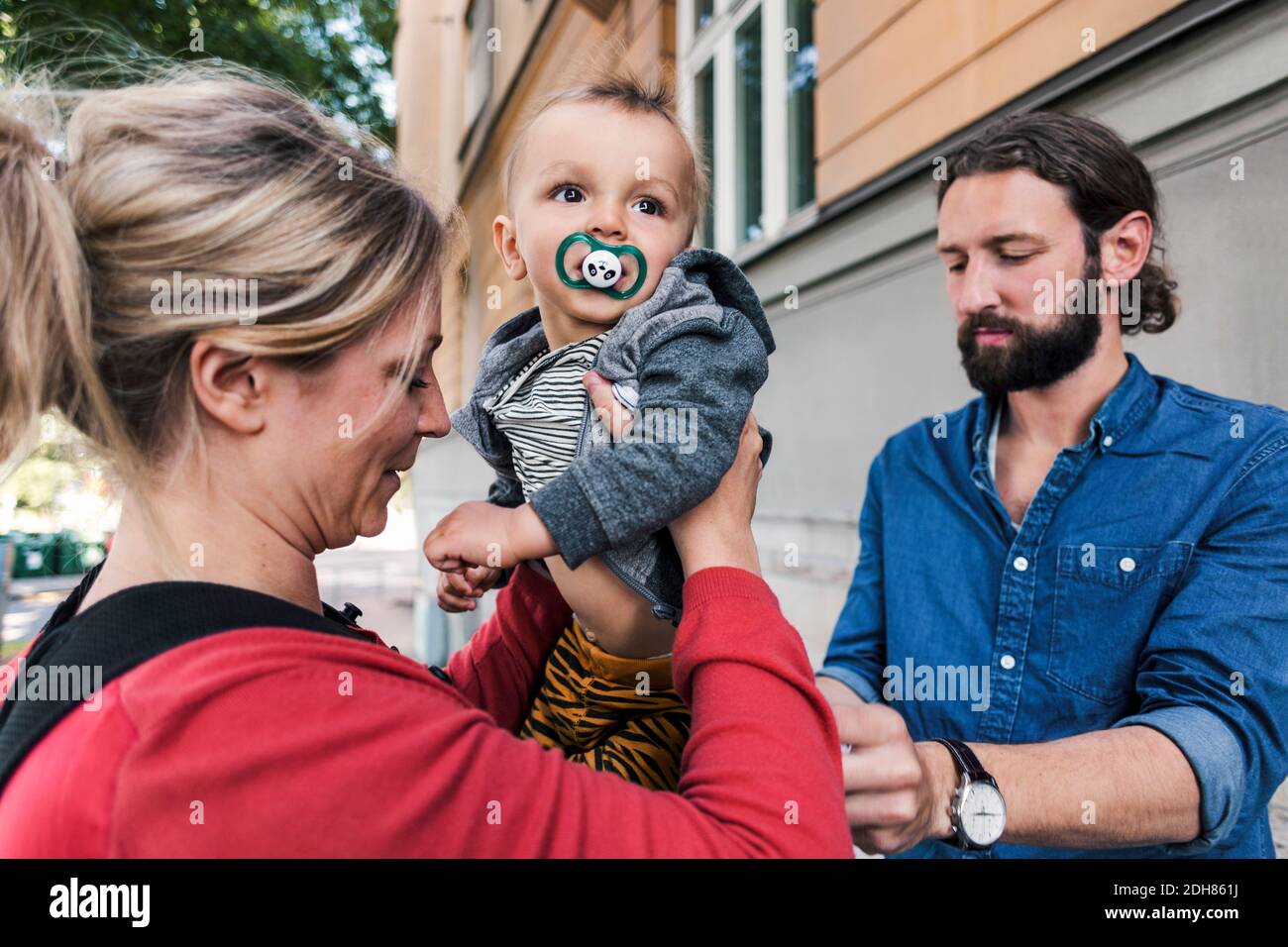 Mid adult parents with baby boy outside house Stock Photo