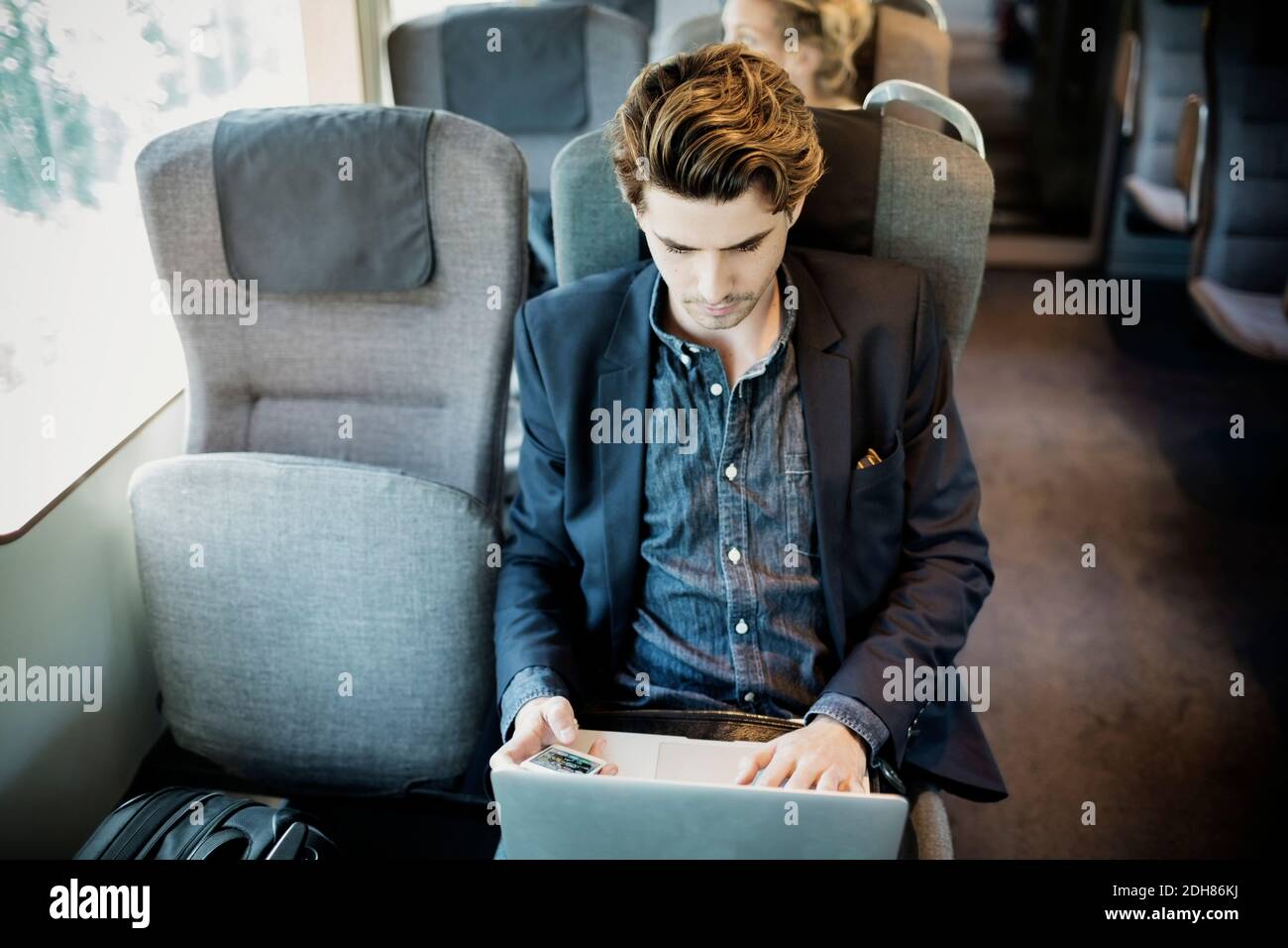 Businessman using laptop in train Stock Photo Alamy