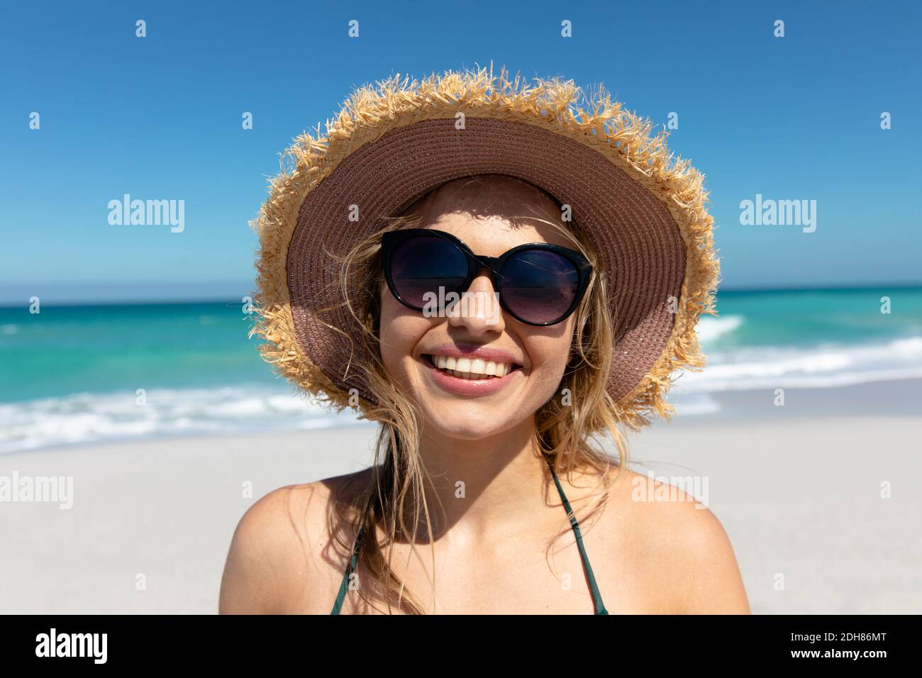 Young woman with hat smiling at the beach Stock Photo - Alamy
