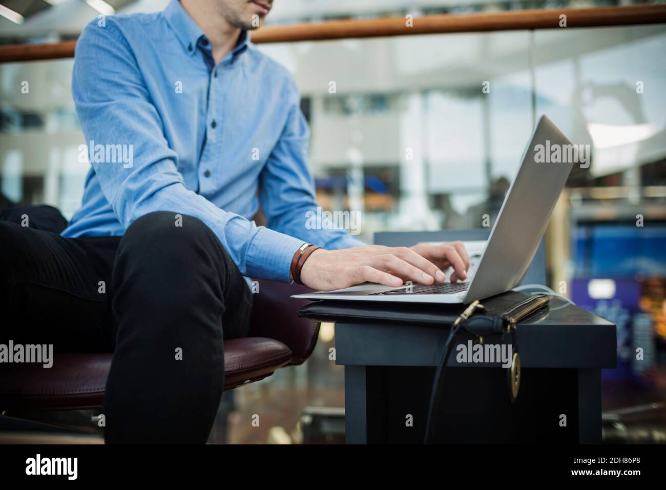 Midsection of businessman using laptop at airport lobby Stock Photo