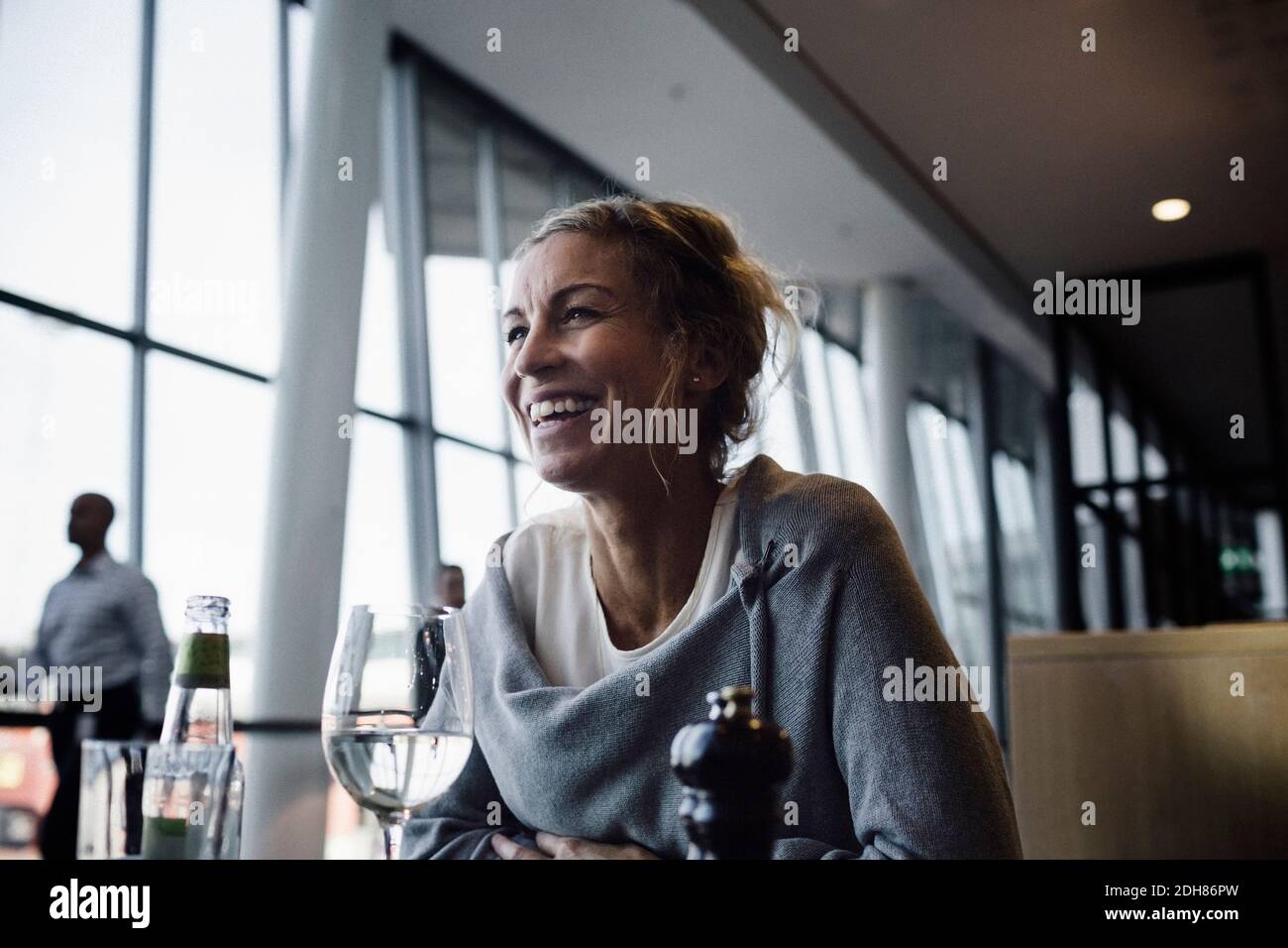 Happy businesswoman sitting at cafe in airport Stock Photo